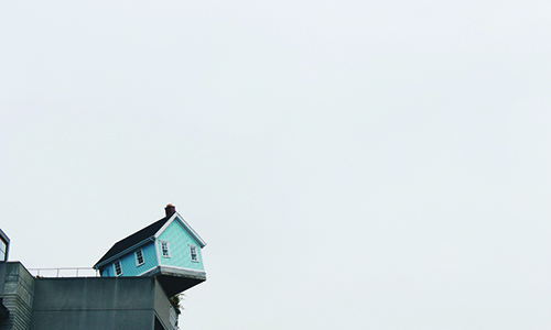 A house hanging off of a cliff over the water