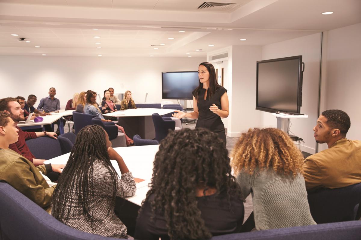 An instructor teaches to a diverse group of students.